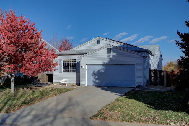 view of front facade featuring driveway, an attached garage, and fence