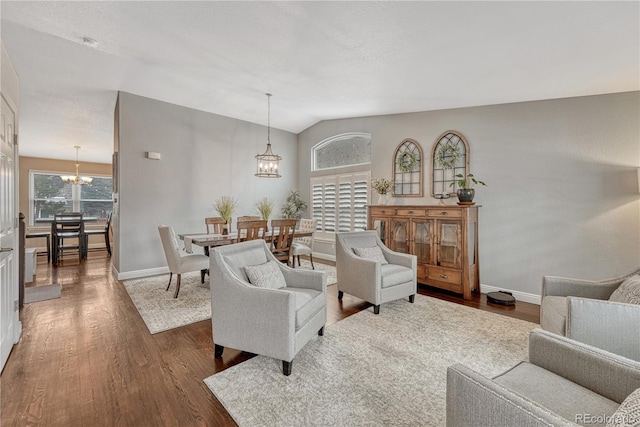 living room featuring a chandelier, vaulted ceiling, and dark hardwood / wood-style floors