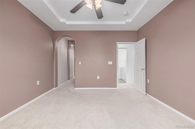 7777 E 23rd Ave Unit 1406, Denver, CO 80238 - empty room featuring a raised ceiling, arched walkways, a ceiling fan, and light colored carpet