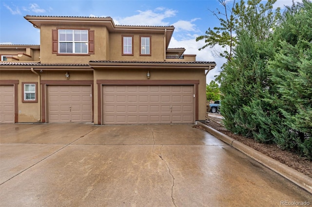7777 E 23rd Ave Unit 1406, Denver, CO 80238 - view of front of property with a garage, driveway, and stucco siding