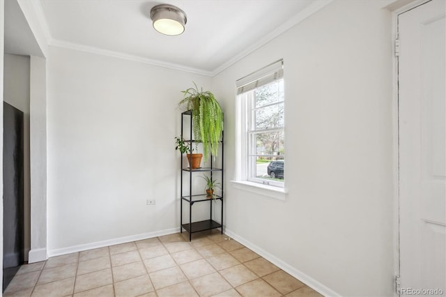 empty room with baseboards, ornamental molding, and light tile patterned flooring