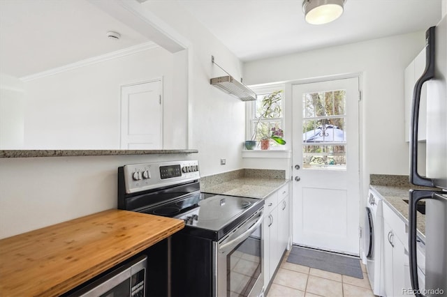 kitchen with stainless steel range with electric cooktop, open shelves, light tile patterned flooring, washer / dryer, and ornamental molding