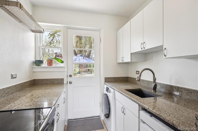 clothes washing area with washer / clothes dryer, laundry area, and a sink