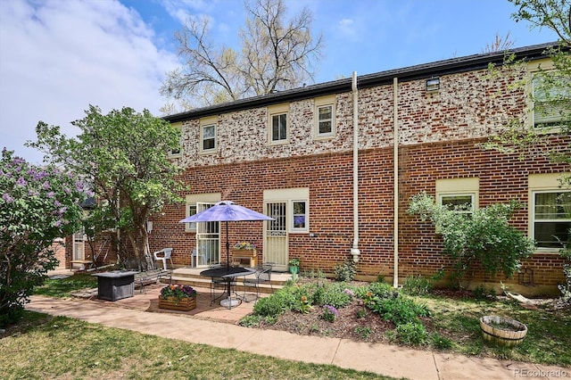 rear view of house with brick siding and a patio area
