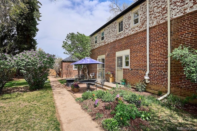 back of property featuring brick siding and a patio
