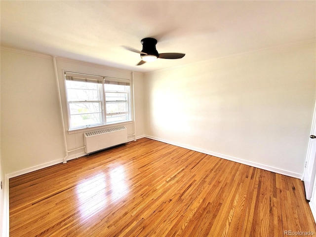 empty room with crown molding, a ceiling fan, radiator, and light wood-style floors
