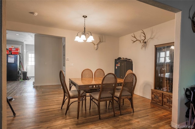 dining room with a notable chandelier and dark hardwood / wood-style floors