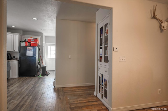 hallway featuring dark hardwood / wood-style floors and a textured ceiling