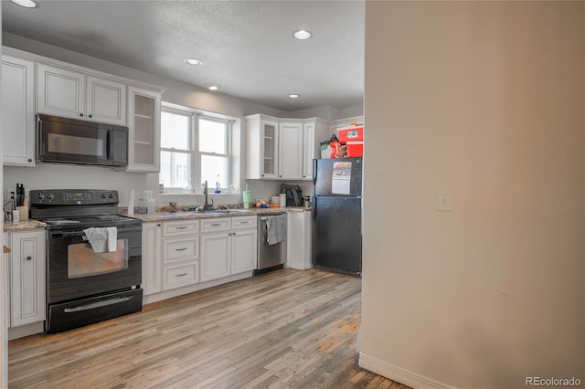 kitchen featuring white cabinetry, sink, and black appliances