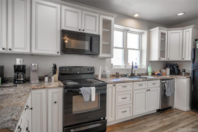 kitchen with sink, black appliances, and white cabinets