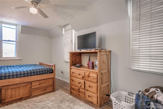 bedroom featuring wood-type flooring, ceiling fan, and a textured ceiling