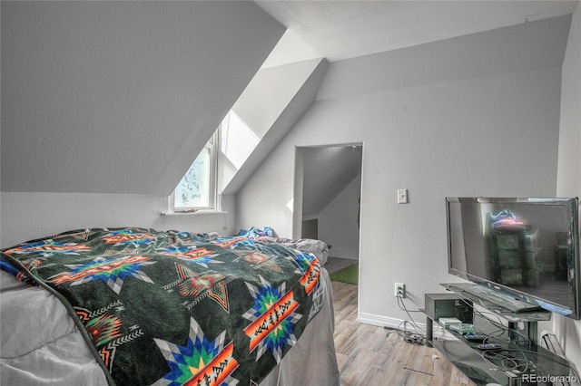 bedroom featuring lofted ceiling and light wood-type flooring