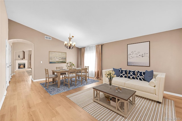 5162 Hubert St, Parker, CO 80134 - living area with arched walkways, light wood-style flooring, lofted ceiling, baseboards, and a chandelier