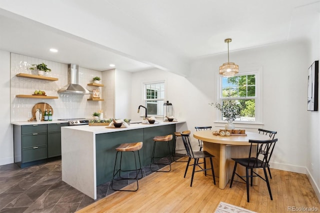 4465 N Umatilla St, Denver, CO 80211 - kitchen featuring wall chimney range hood, open shelves, backsplash, light countertops, and a kitchen breakfast bar