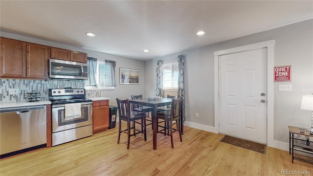 kitchen featuring tasteful backsplash, stainless steel appliances, and light hardwood / wood-style floors