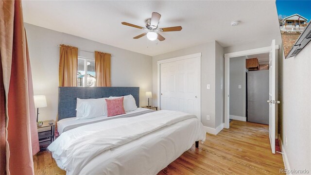 bedroom with a closet, ceiling fan, and light wood-type flooring