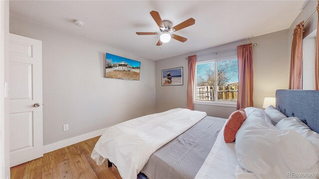 bedroom with ceiling fan and light hardwood / wood-style floors