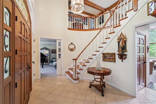 5475 S Laredo St, Centennial, CO 80015 - foyer entrance with stairs, light tile patterned floors, a chandelier, a towering ceiling, and light colored carpet