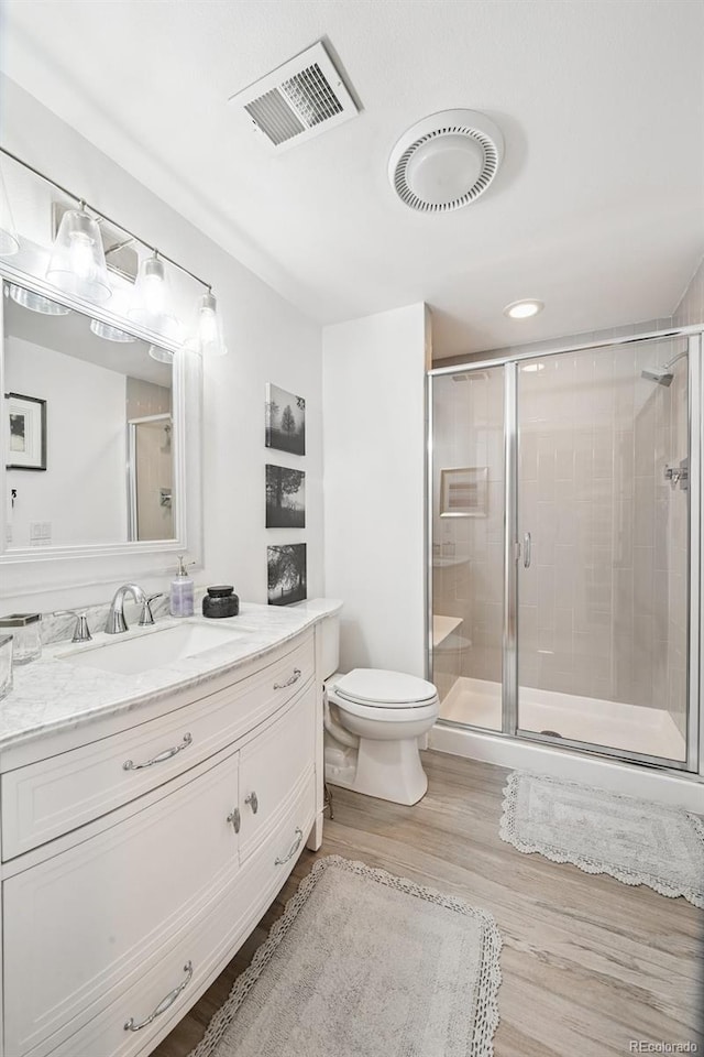 5475 S Laredo St, Centennial, CO 80015 - bathroom featuring vanity, a stall shower, and wood finished floors