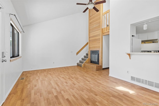 323 S Taft Ct Unit 26, Louisville, CO 80027 - unfurnished living room with light wood-style flooring, a ceiling fan, stairs, and high vaulted ceiling