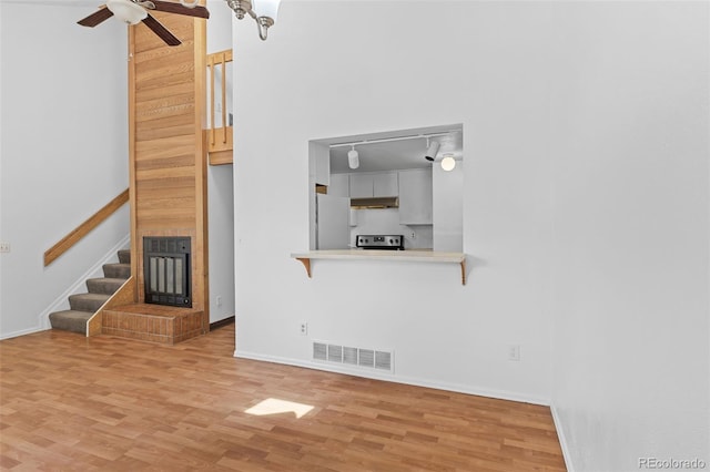 323 S Taft Ct Unit 26, Louisville, CO 80027 - unfurnished living room with wood finished floors, a ceiling fan, stairs, and rail lighting