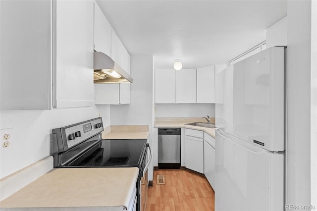 323 S Taft Ct Unit 26, Louisville, CO 80027 - kitchen with appliances with stainless steel finishes, custom range hood, white cabinets, and light wood-style flooring