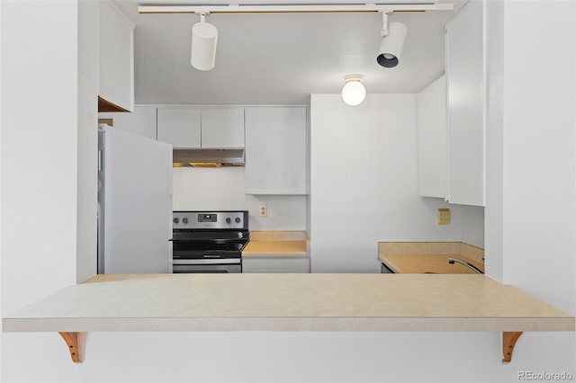 323 S Taft Ct Unit 26, Louisville, CO 80027 - kitchen with electric stove, under cabinet range hood, freestanding refrigerator, white cabinets, and a peninsula