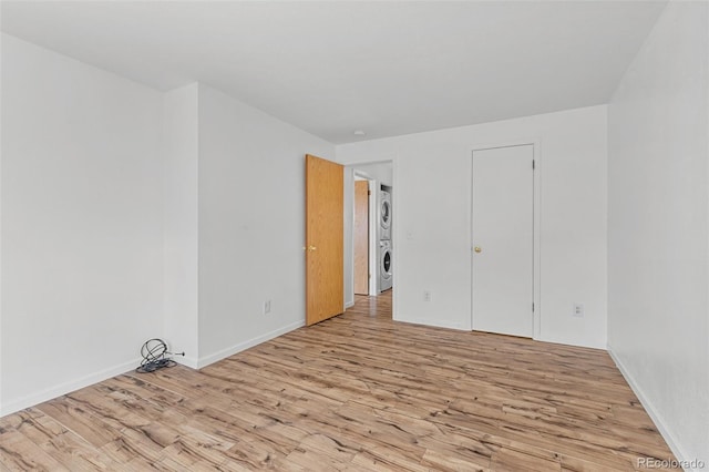 323 S Taft Ct Unit 26, Louisville, CO 80027 - unfurnished bedroom featuring stacked washer and clothes dryer and wood finished floors