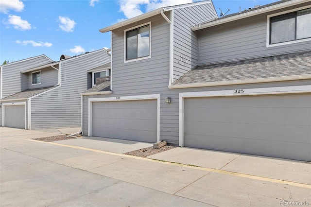 323 S Taft Ct Unit 26, Louisville, CO 80027 - view of front facade featuring a shingled roof, a garage, and driveway