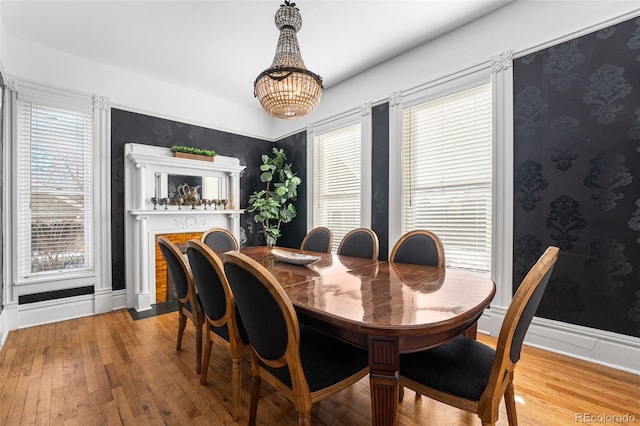 dining area with wood-type flooring and a notable chandelier