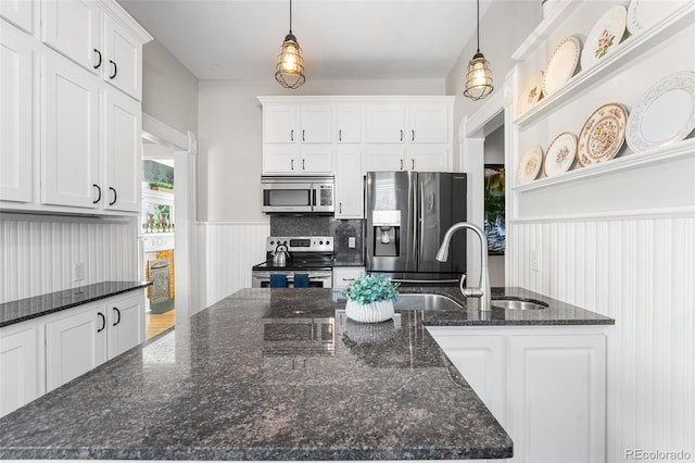 kitchen with decorative light fixtures, dark stone counters, and appliances with stainless steel finishes