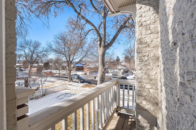 view of snow covered back of property