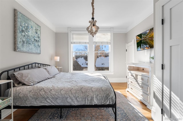 bedroom with ornamental molding and light hardwood / wood-style flooring