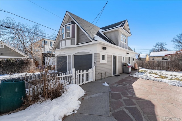 view of snowy exterior with a garage