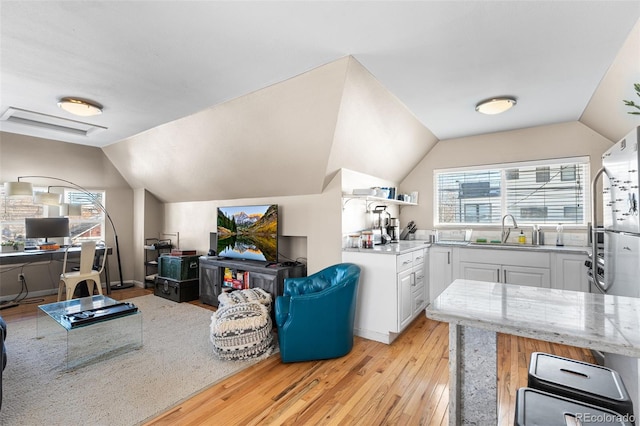 interior space with sink, a wealth of natural light, light hardwood / wood-style flooring, and white cabinets