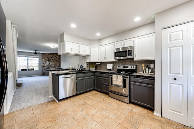 8231 S Fillmore Way, Centennial, CO 80122 - kitchen with appliances with stainless steel finishes, white cabinetry, decorative backsplash, light carpet, and a sink