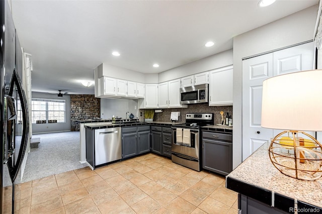 8231 S Fillmore Way, Centennial, CO 80122 - kitchen with appliances with stainless steel finishes, white cabinetry, a sink, light carpet, and backsplash