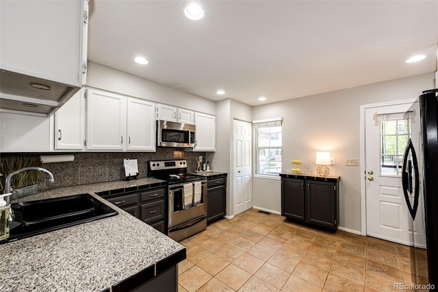 8231 S Fillmore Way, Centennial, CO 80122 - kitchen with stainless steel appliances, a sink, white cabinets, backsplash, and recessed lighting