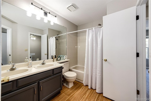 8231 S Fillmore Way, Centennial, CO 80122 - bathroom featuring wood finished floors, toilet, shower / bath combo, double vanity, and ceiling fan