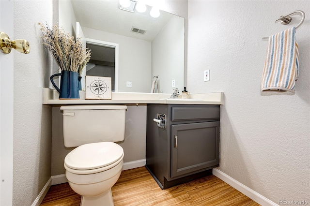 8231 S Fillmore Way, Centennial, CO 80122 - bathroom featuring wood finished floors, toilet, vanity, and baseboards