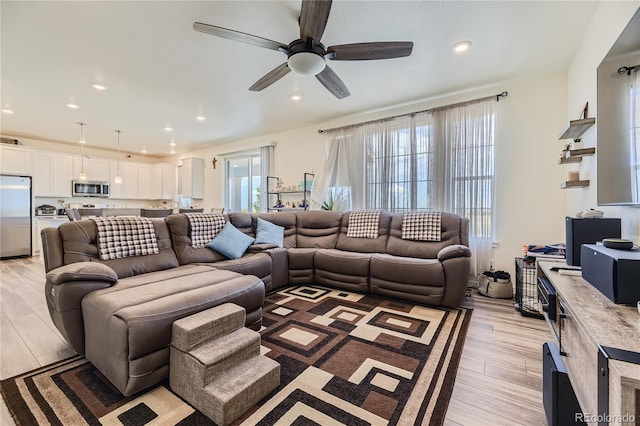 living room featuring light wood-style flooring, ceiling fan, and recessed lighting