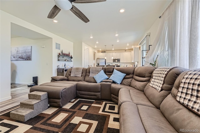 living area featuring a ceiling fan, recessed lighting, indoor wet bar, and baseboards