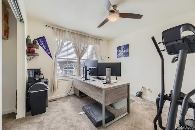 office featuring a ceiling fan, light colored carpet, and baseboards