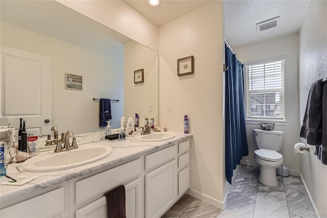 bathroom featuring toilet, marble finish floor, a sink, and visible vents