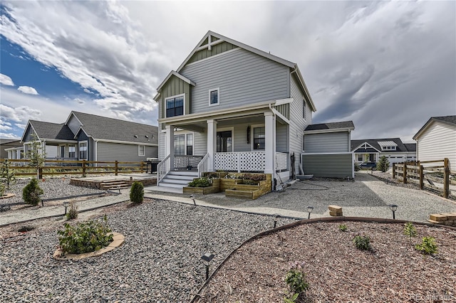 view of front of property with covered porch, a patio, board and batten siding, and fence