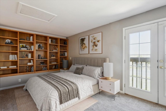 bedroom featuring multiple windows, light carpet, and attic access