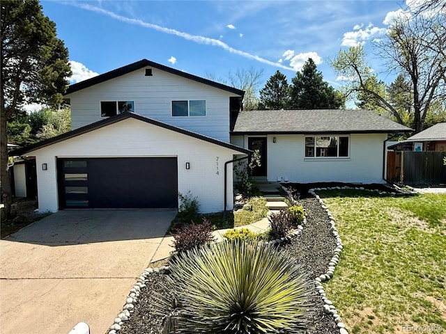 split level home featuring brick siding, fence, a garage, concrete driveway, and a front yard