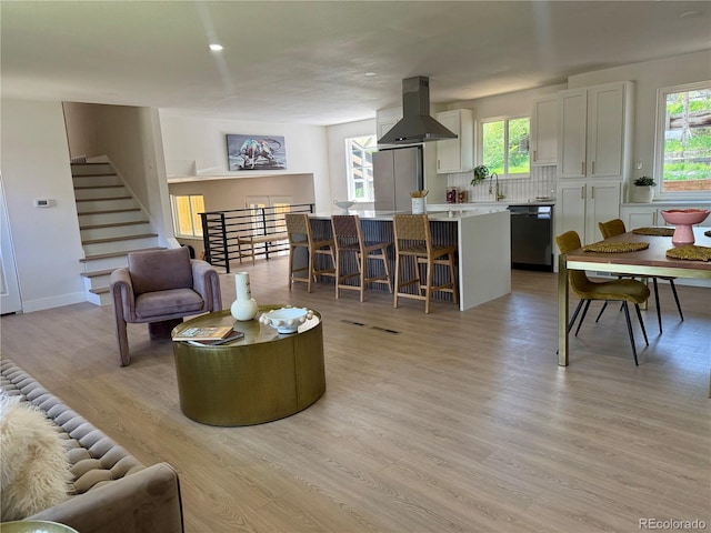living area with light wood finished floors and stairs