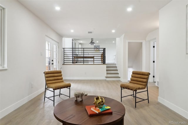 living area with stairway, light wood finished floors, baseboards, and recessed lighting