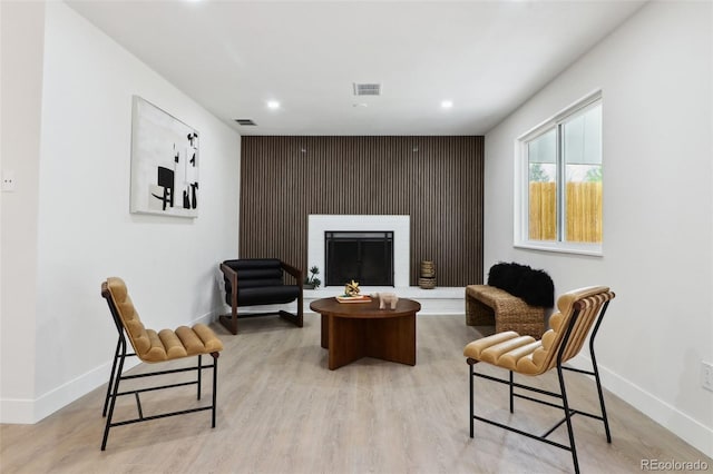 sitting room with light wood-style flooring, baseboards, visible vents, and recessed lighting